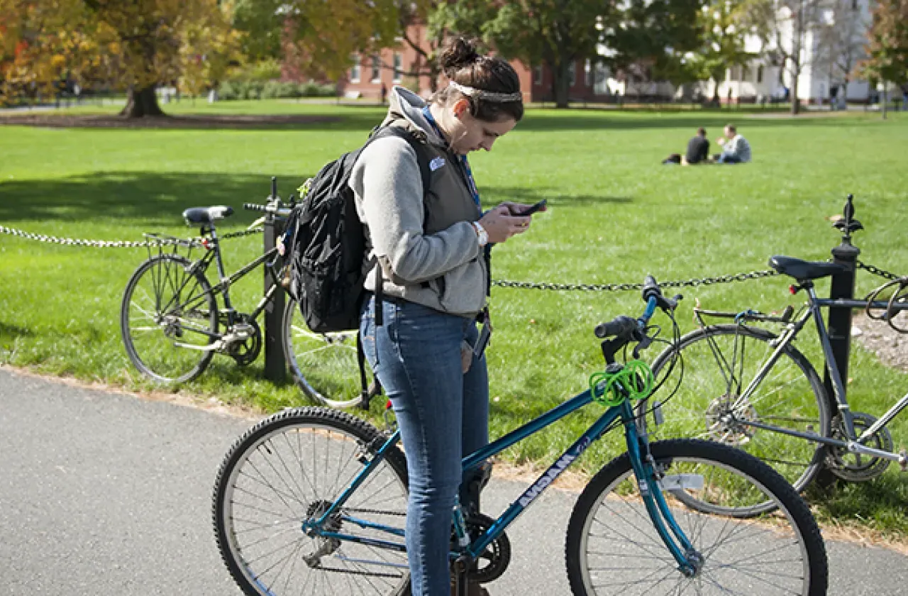 女孩一边骑自行车一边看手机