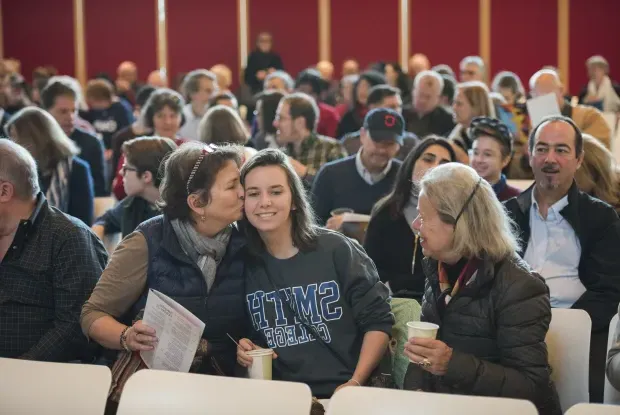 Student and their family at an assembly during Family Weekend.